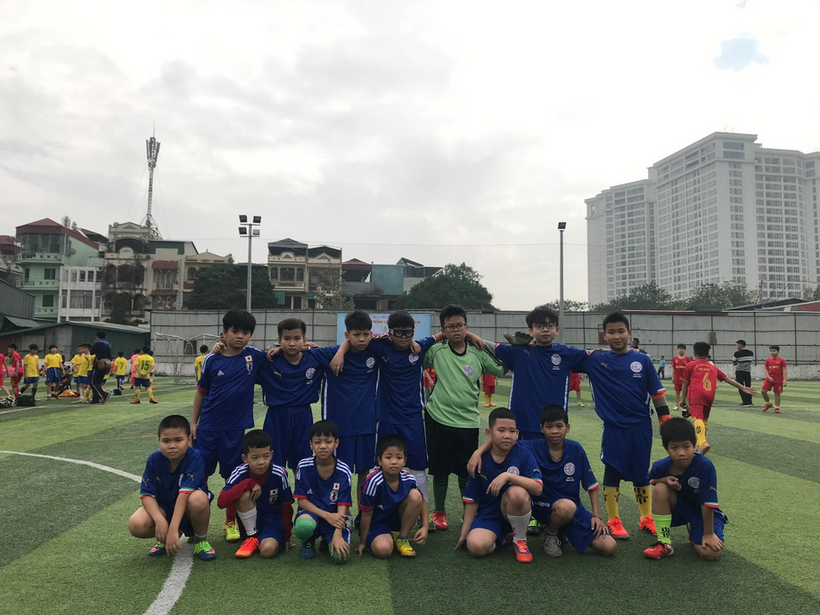 A group of boys in blue uniforms on a field

Description automatically generated
