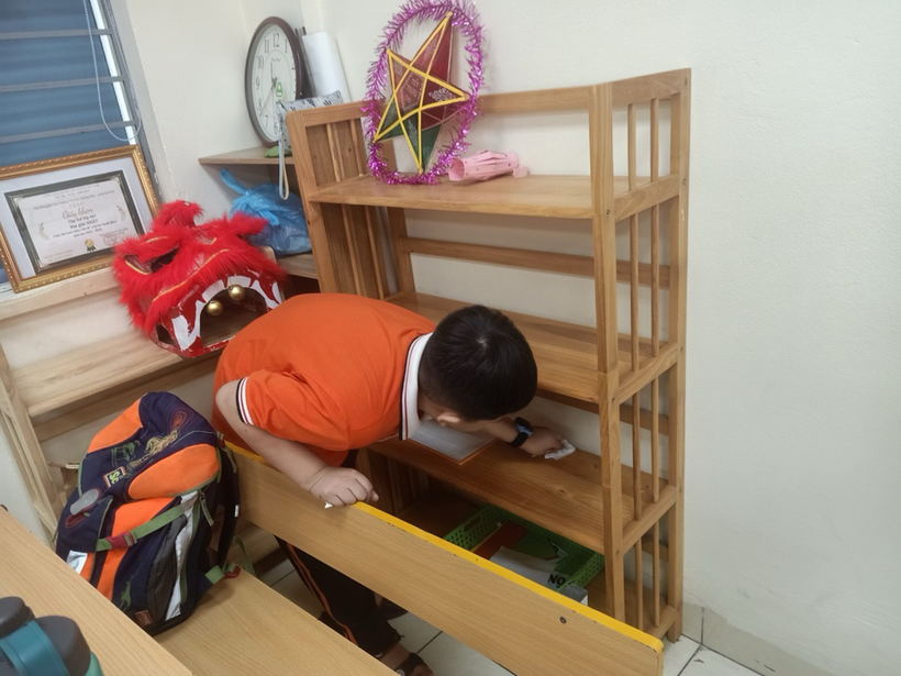 A child looking at a shelf

Description automatically generated