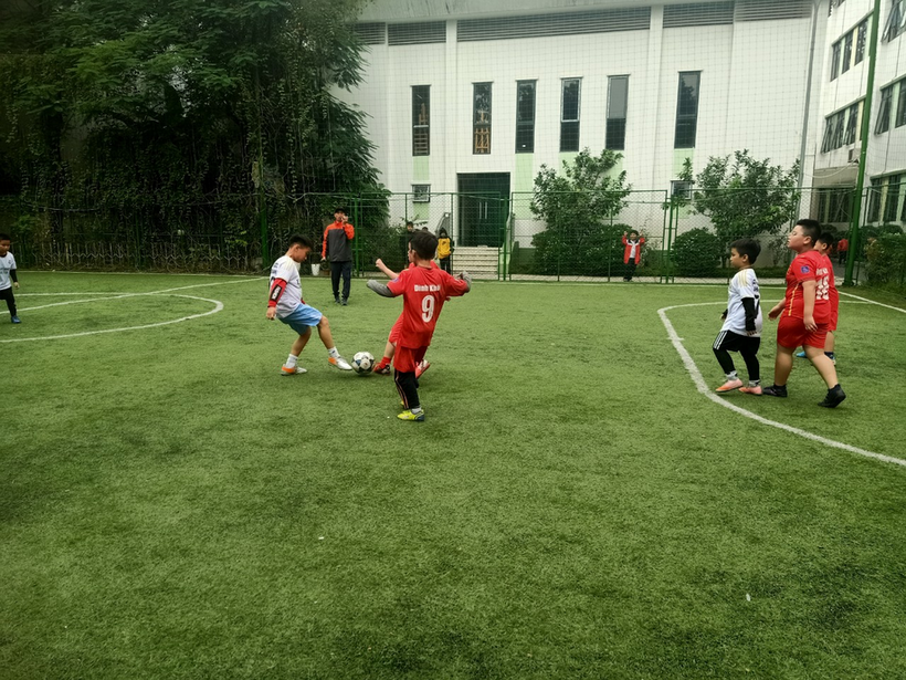 A group of kids playing footballDescription automatically generated