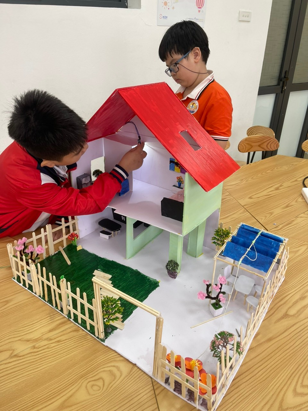 Two boys looking at a model of a house

Description automatically generated