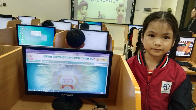 A child in a classroom with computers

Description automatically generated