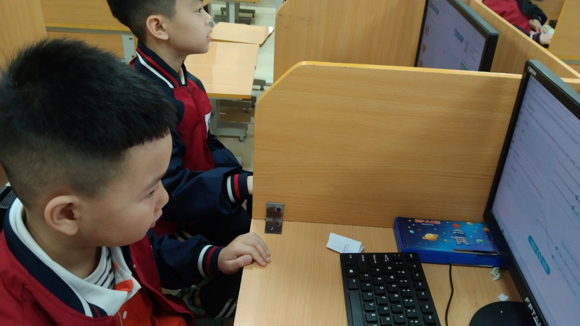A group of boys sitting at a desk

Description automatically generated
