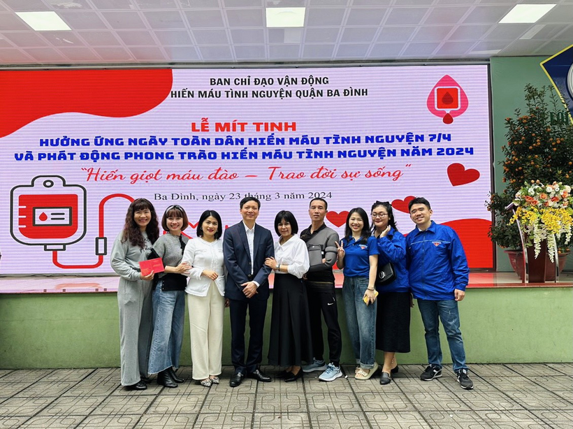 A group of people standing in front of a large signDescription automatically generated