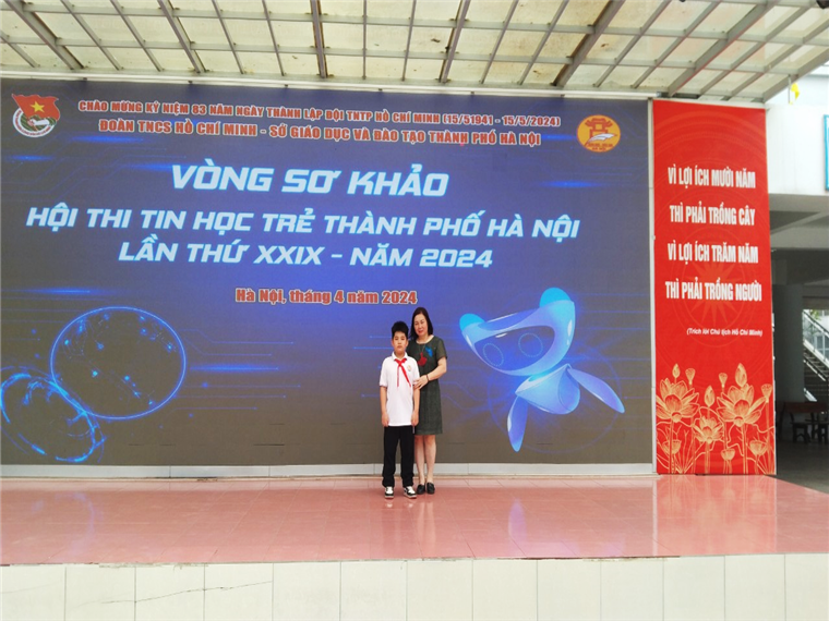 A person and a child standing in front of a large sign

Description automatically generated
