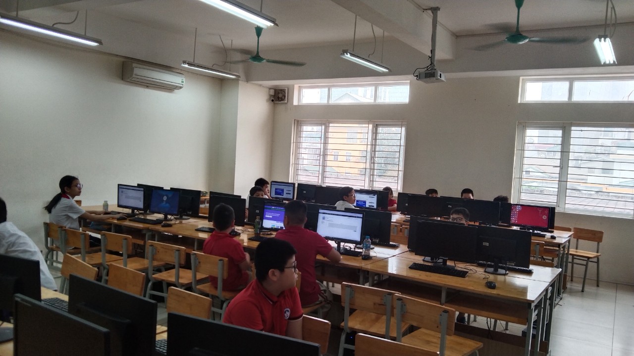 A group of people in a room with computers

Description automatically generated