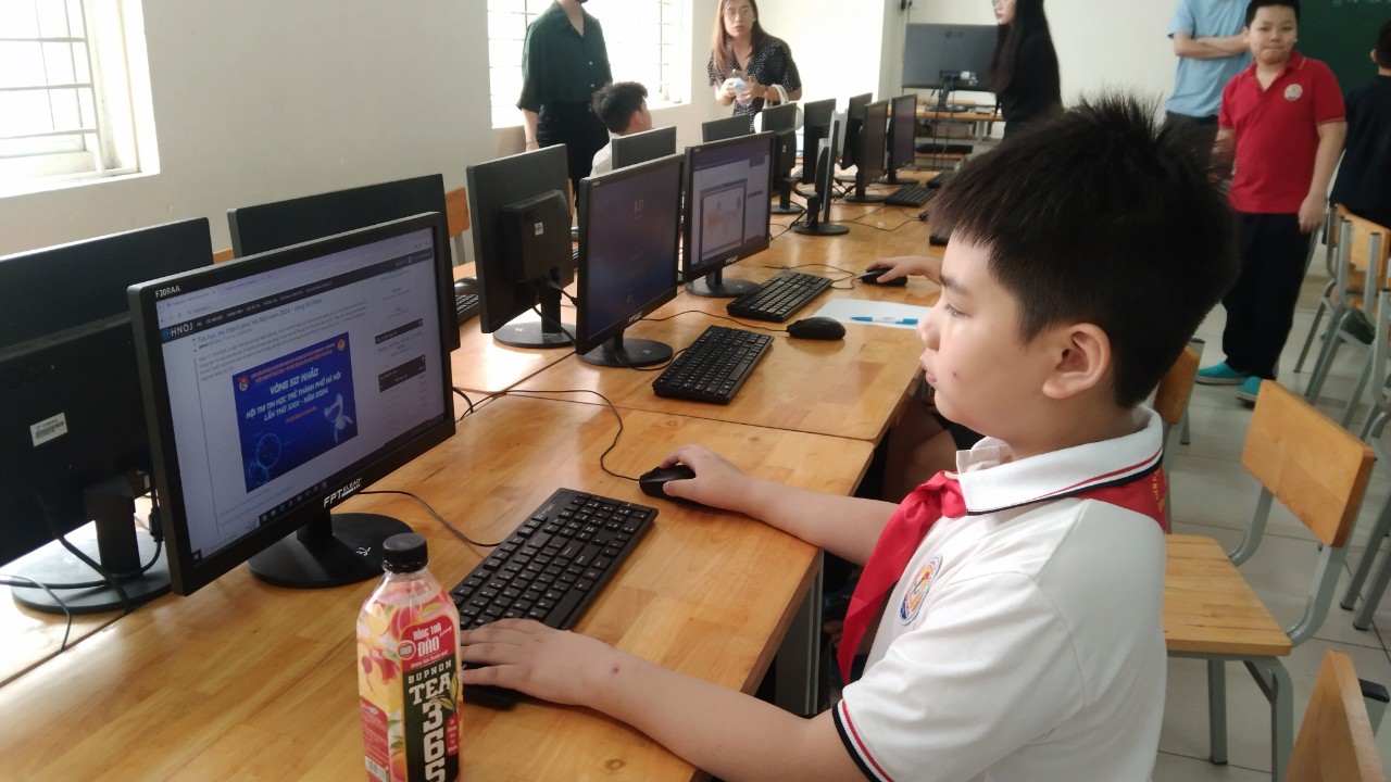 A child sitting at a desk with computers

Description automatically generated