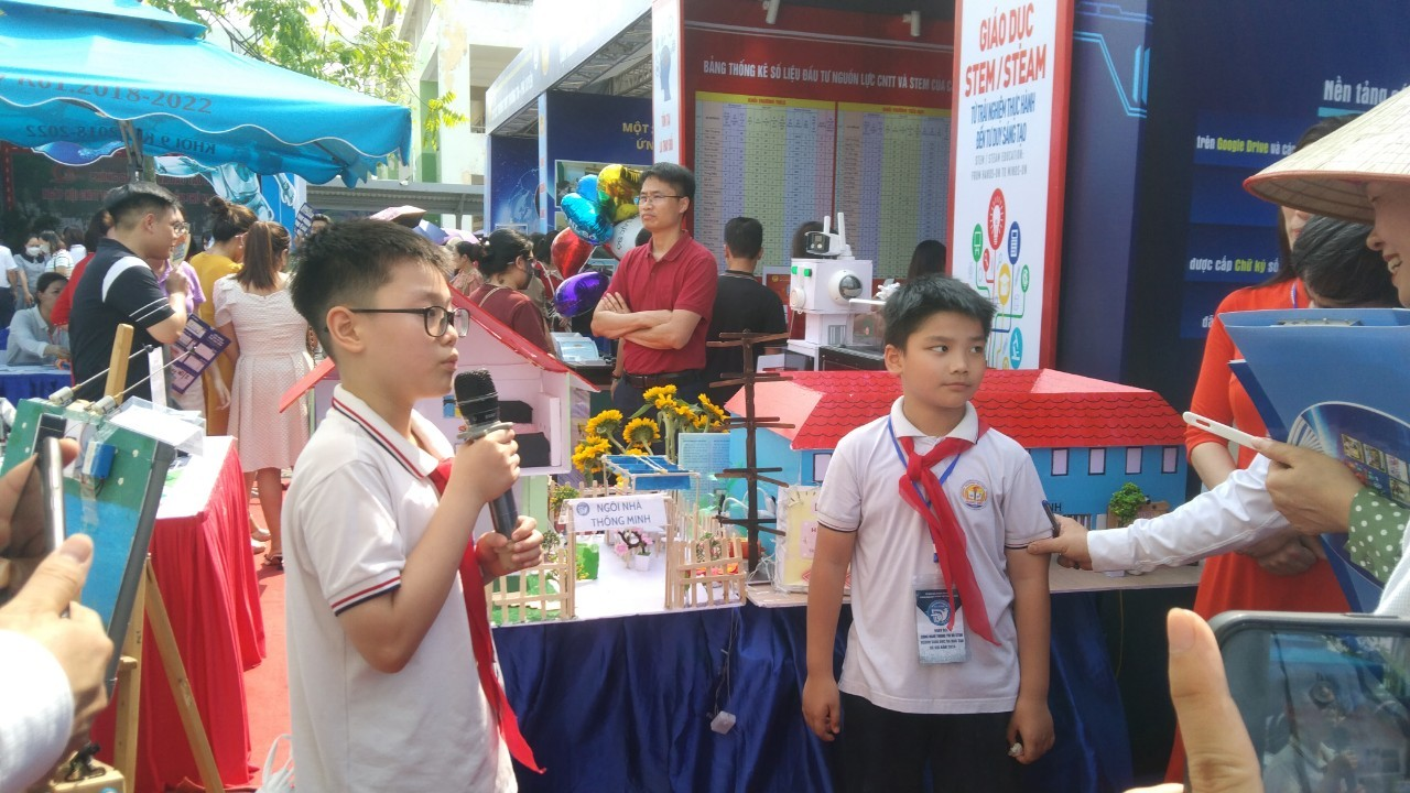 A group of boys standing in front of a table with a microphone

Description automatically generated